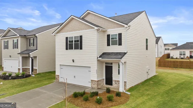a view of a white house next to a yard with big trees