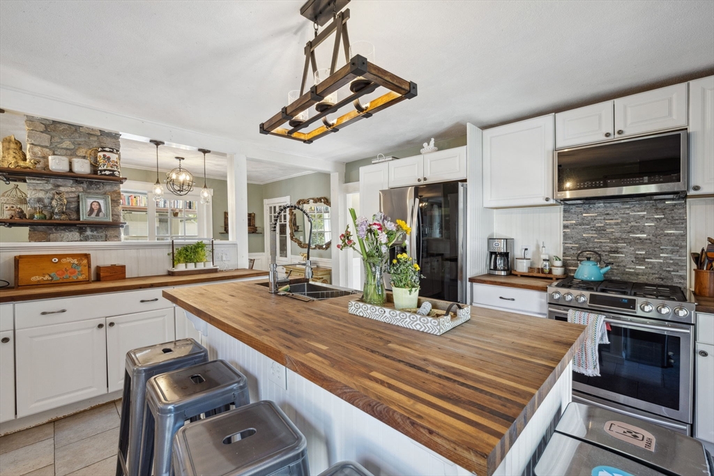 46 Appleton Street Saugus, MA 01906 - Photo 26 of 42 a kitchen with kitchen island granite countertop a stove cabinets and microwave