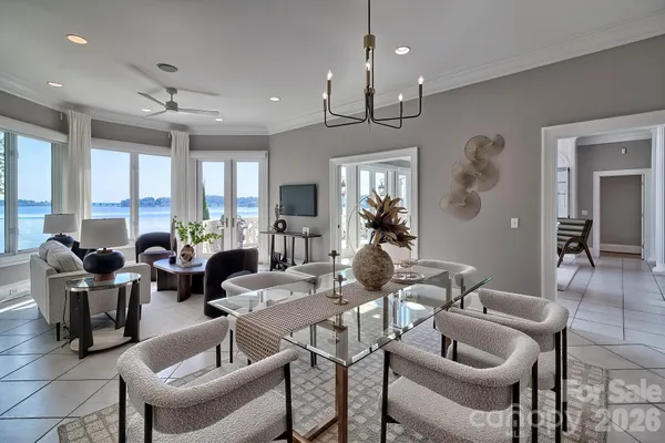 a living room with furniture kitchen view and a chandelier
