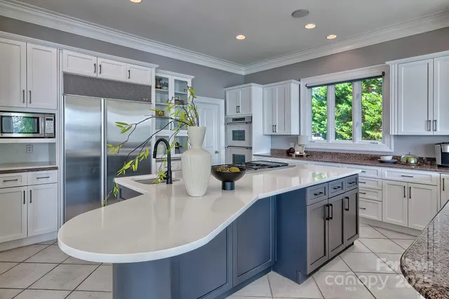 a kitchen with kitchen island granite countertop a sink stainless steel appliances and cabinets