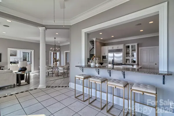 a living room with furniture a chandelier and kitchen view