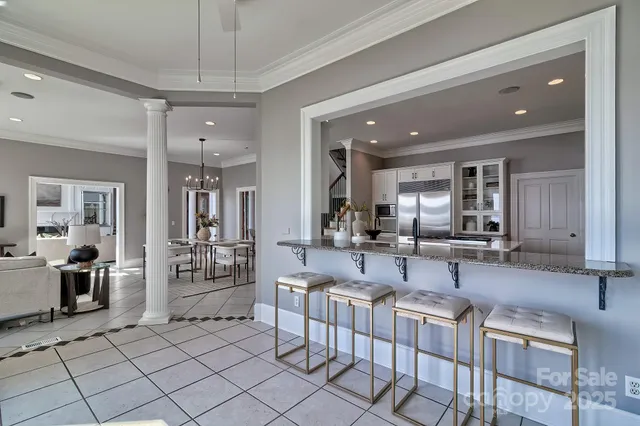 a living room with furniture a chandelier and kitchen view