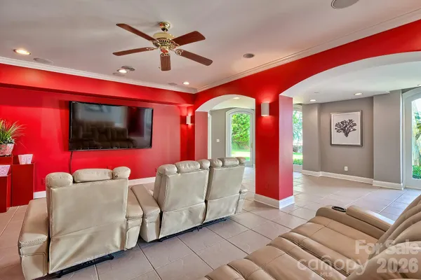 a living room with furniture a flat screen tv and a large window