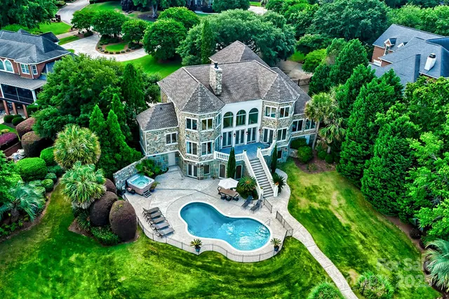 an aerial view of a house with swimming pool a patio and yard