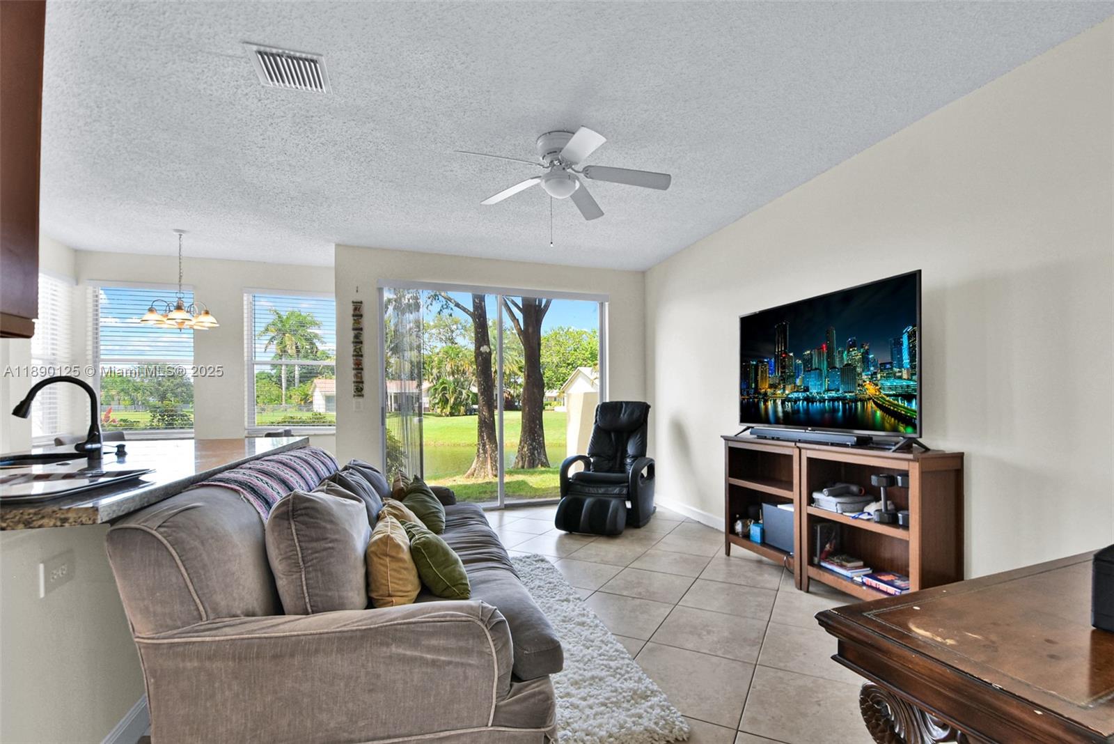 8713 Northwest 6th Court, Unit 8713 Coral Springs, FL 33071 - Photo 11 of 38 a living room with furniture a flat screen tv and a large window