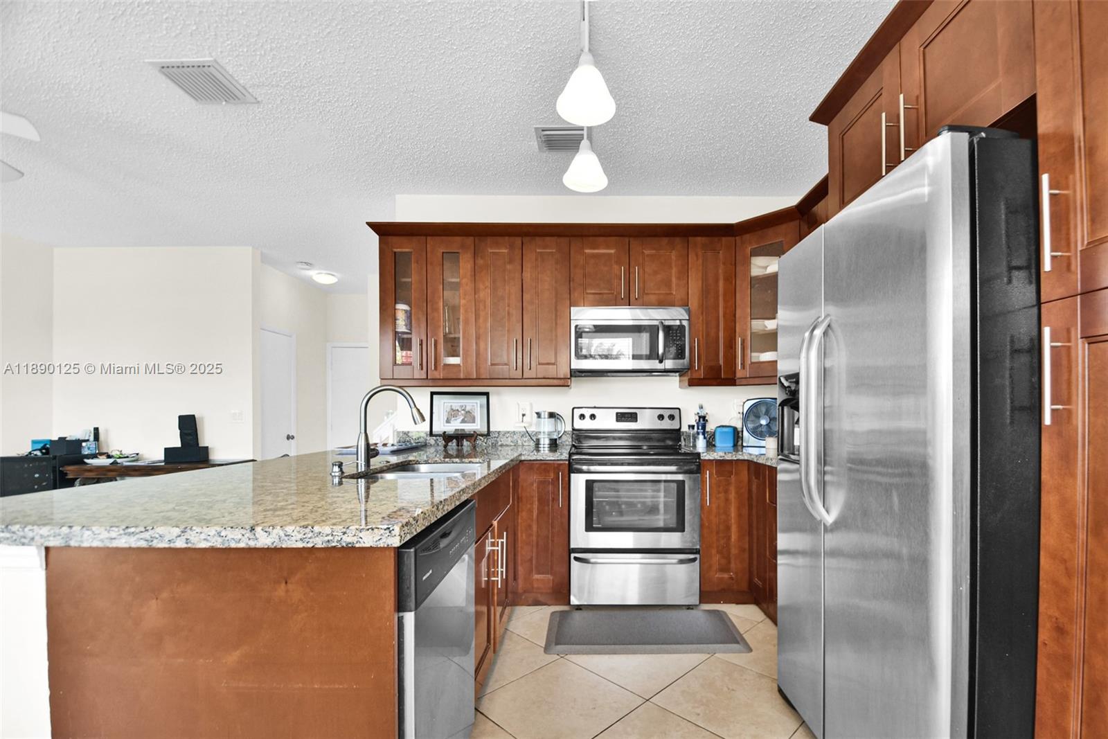 8713 Northwest 6th Court, Unit 8713 Coral Springs, FL 33071 - Photo 14 of 38 a kitchen with stainless steel appliances granite countertop a sink a stove a refrigerator a washer dryer and a dining table