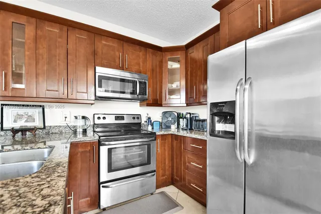 a kitchen with stainless steel appliances granite countertop a stove a sink and a microwave