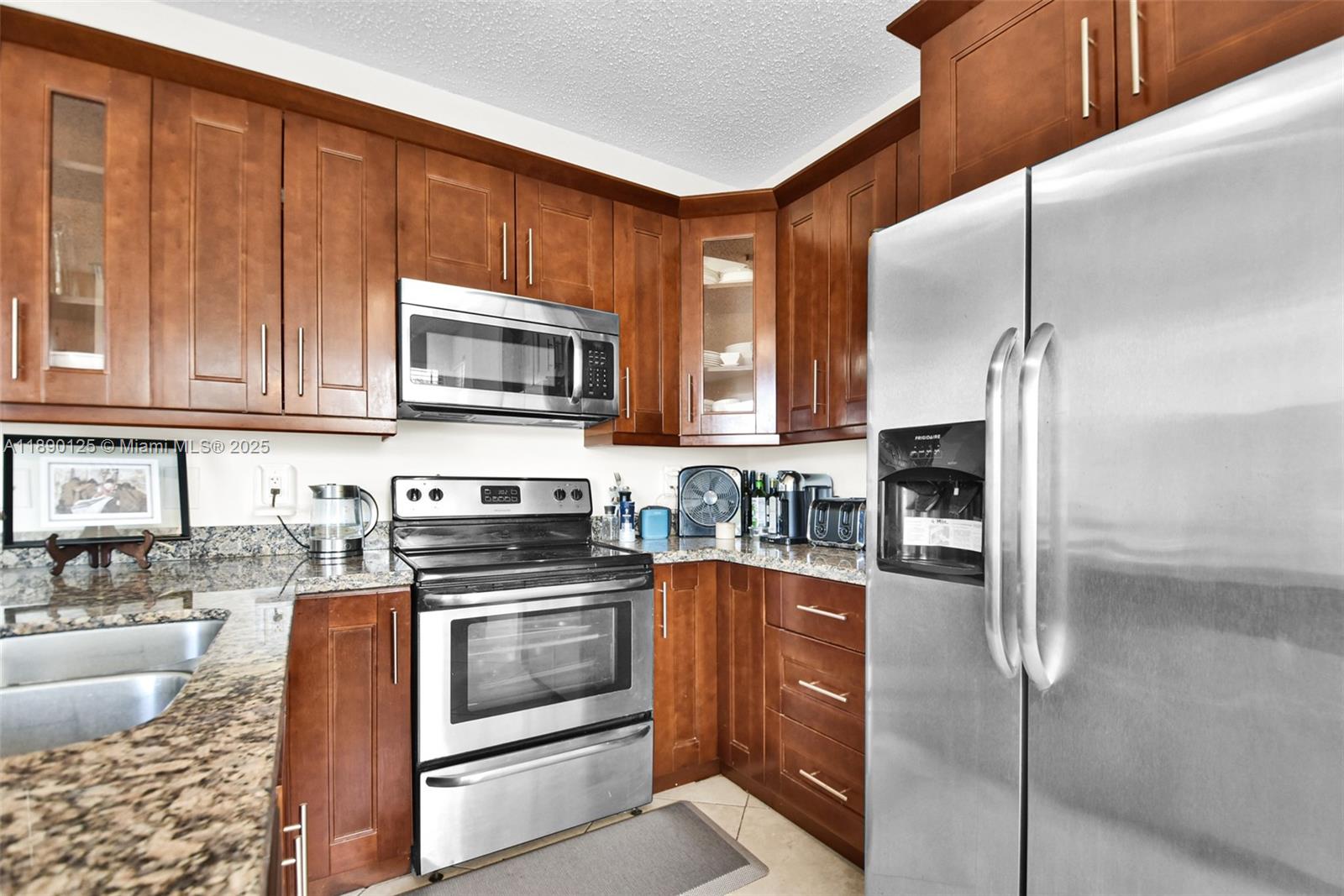 8713 Northwest 6th Court, Unit 8713 Coral Springs, FL 33071 - Photo 16 of 38 a kitchen with stainless steel appliances granite countertop a stove a sink and a microwave