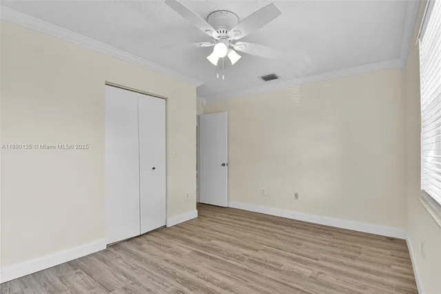 a view of an empty room with a window and a fan