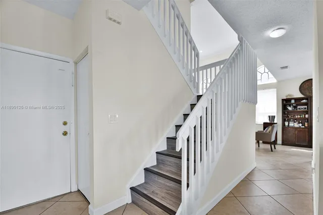 a view of staircase with lots of frames and white walls
