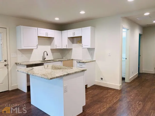 a kitchen with a sink a stove a refrigerator and white cabinets