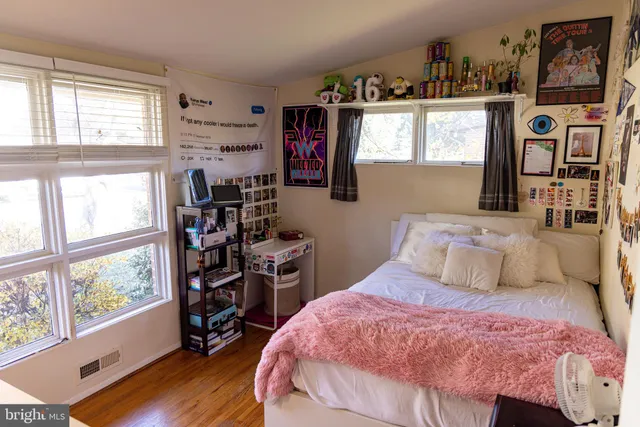 a bedroom with a bed a dresser next to a window