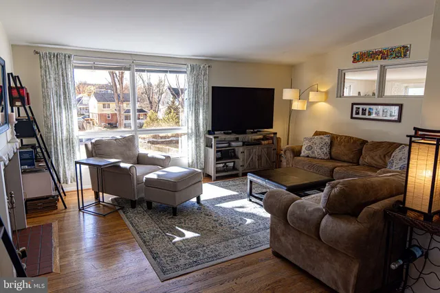 a living room with furniture a flat screen tv and a large window