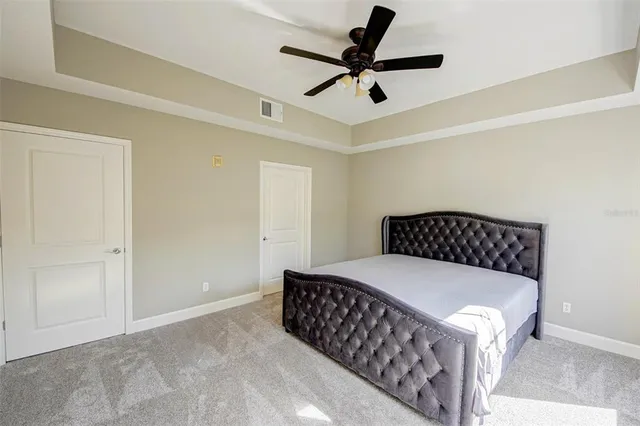 a bedroom with a large bed and a ceiling fan