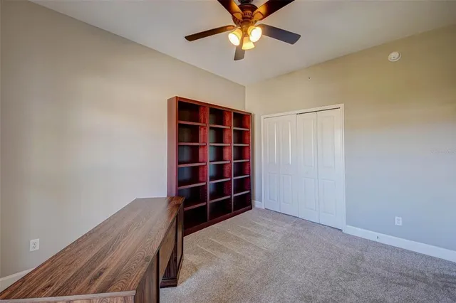 a view of an empty room with a cabinet and a ceiling fan