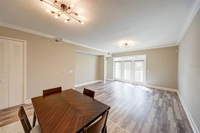 a view of a room with wooden floor windows and chandelier fan