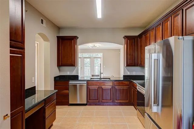 a kitchen with stainless steel appliances granite countertop a stove a refrigerator and a sink