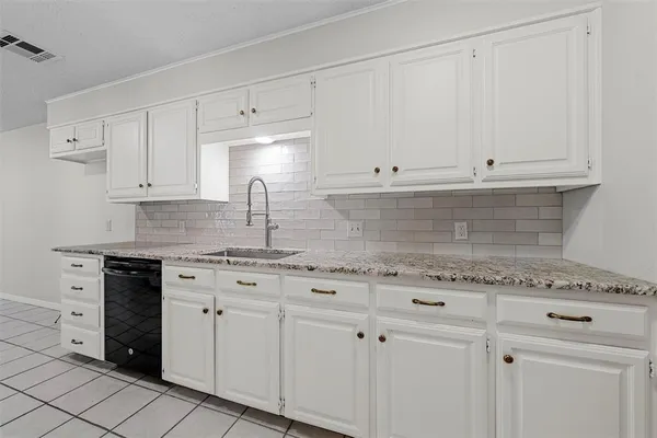 a kitchen with granite countertop white cabinets and white appliances