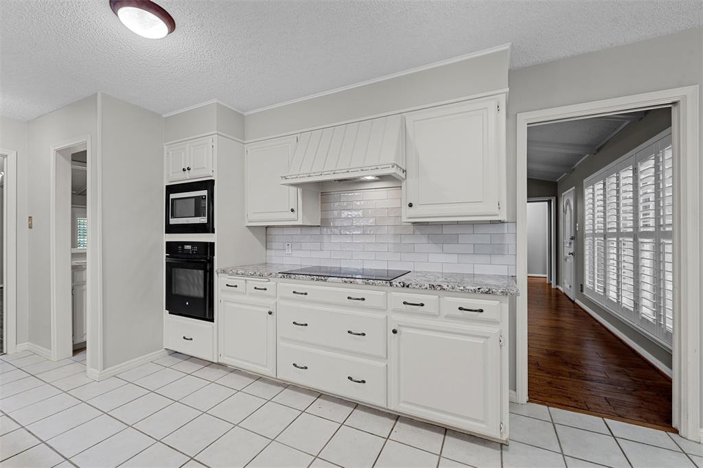 4108 Old Mill Road Waco, TX 76710 - Photo 14 of 40 a kitchen with white cabinets and appliances