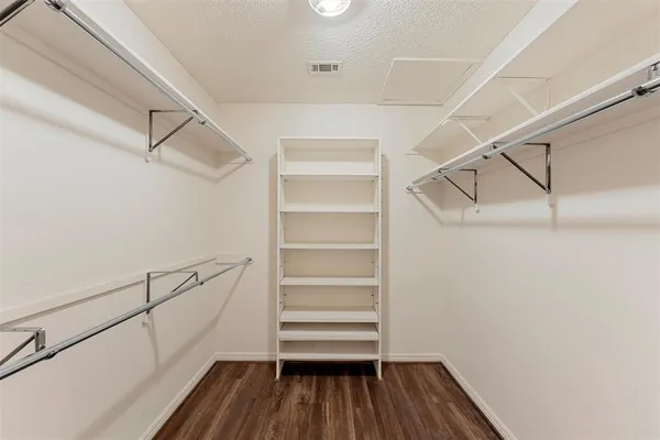 a view of walk in closet with empty racks