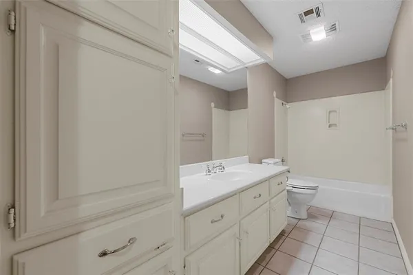 a spacious bathroom with a granite countertop sink a toilet and a mirror