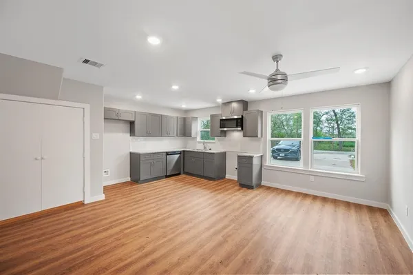 a view of an empty room with a window and wooden floor