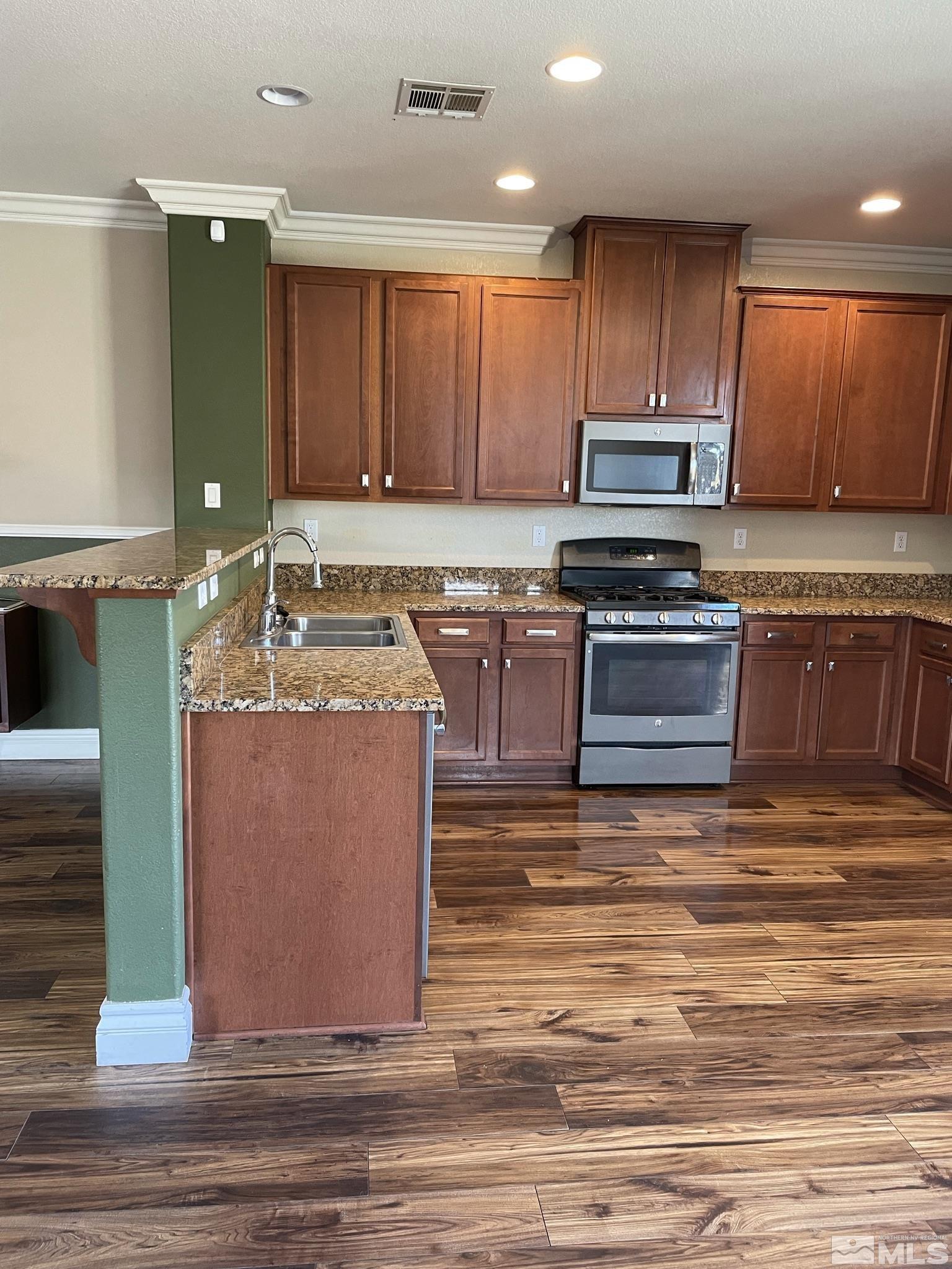 8945 Convair Way Reno, NV 89506 - Photo 11 of 26 a kitchen with stainless steel appliances granite countertop a sink stove and cabinets