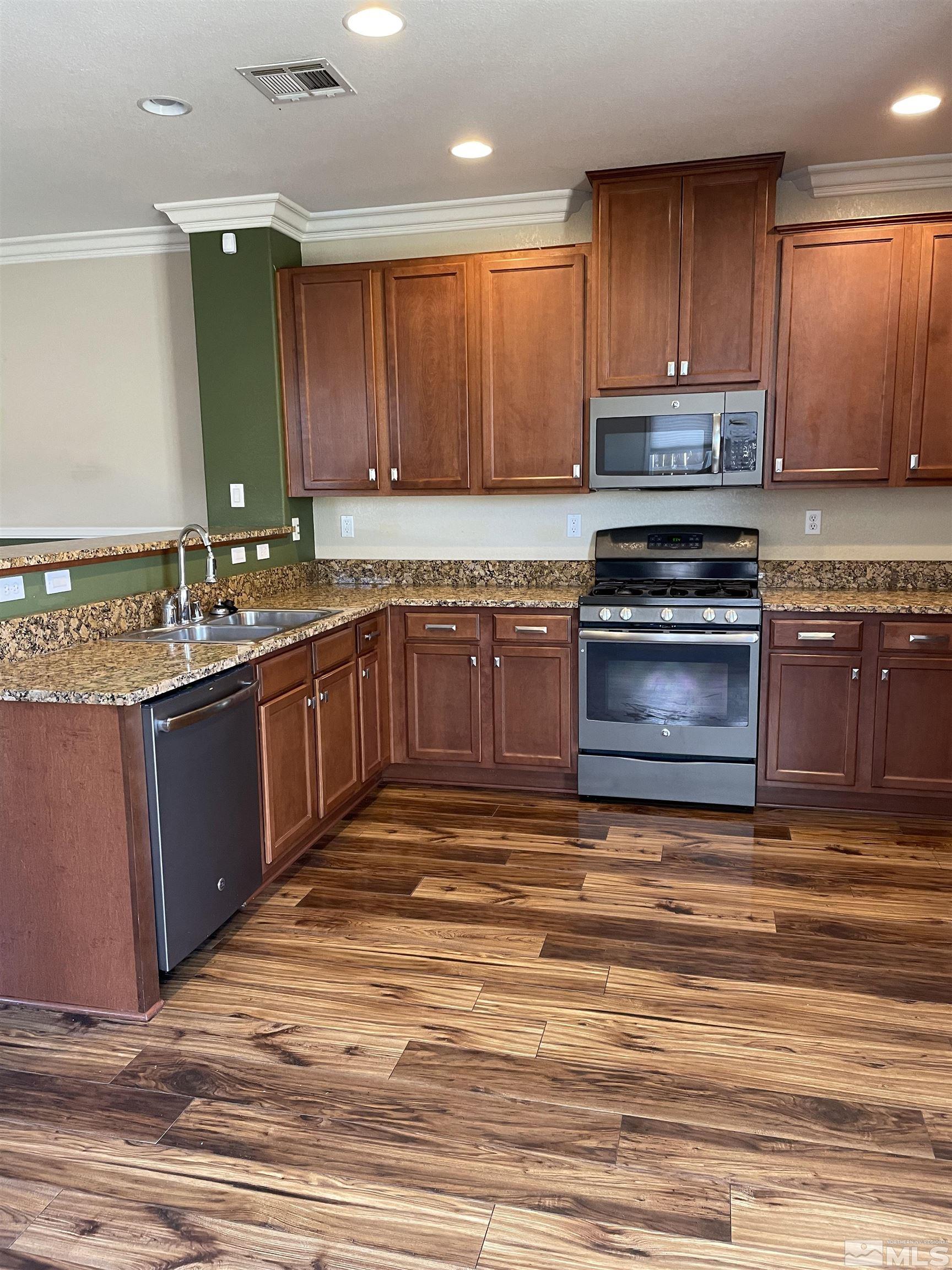 8945 Convair Way Reno, NV 89506 - Photo 12 of 26 a kitchen with stainless steel appliances granite countertop a sink stove and cabinets