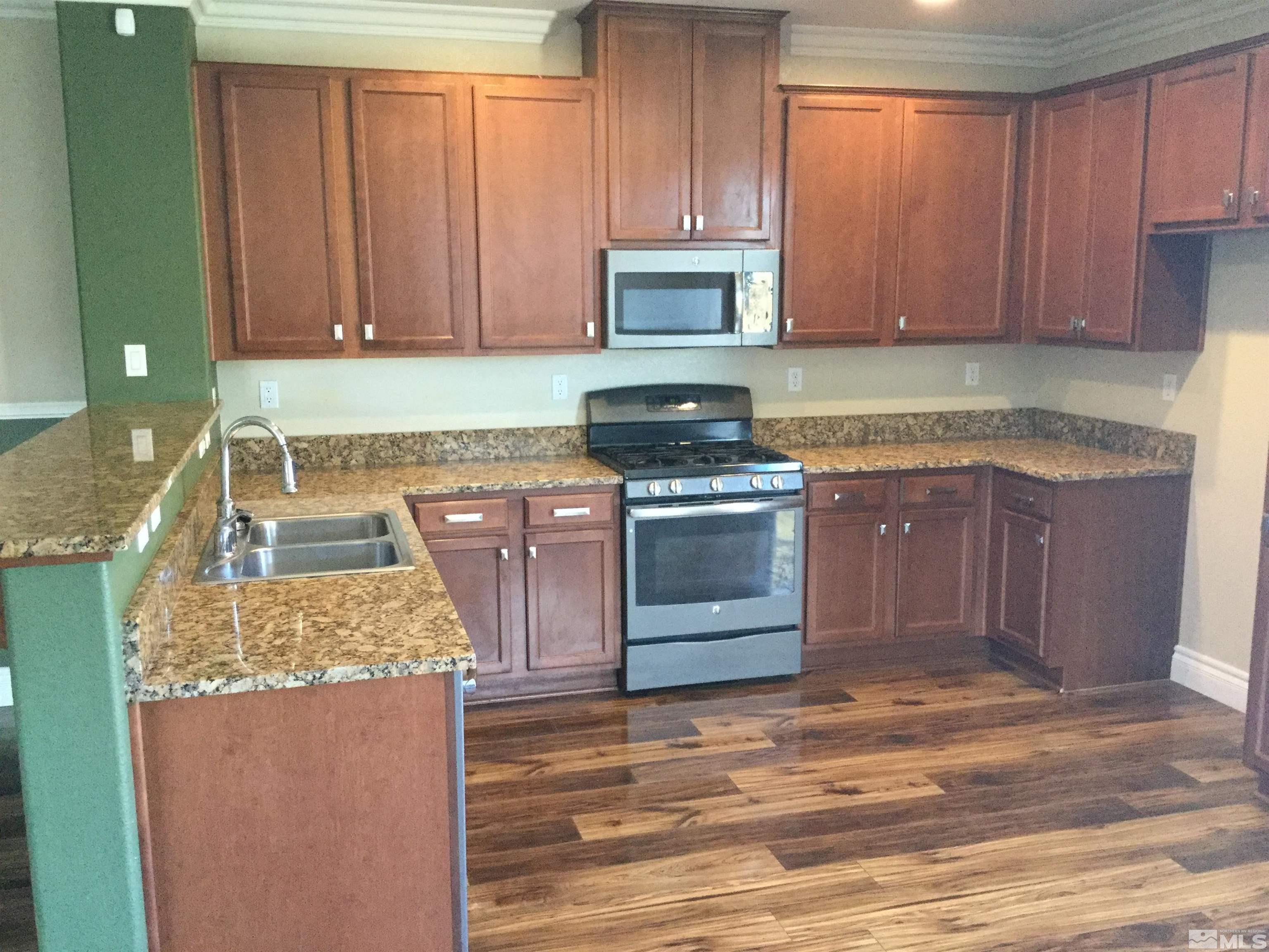8945 Convair Way Reno, NV 89506 - Photo 9 of 26 a kitchen with a sink stove and cabinets
