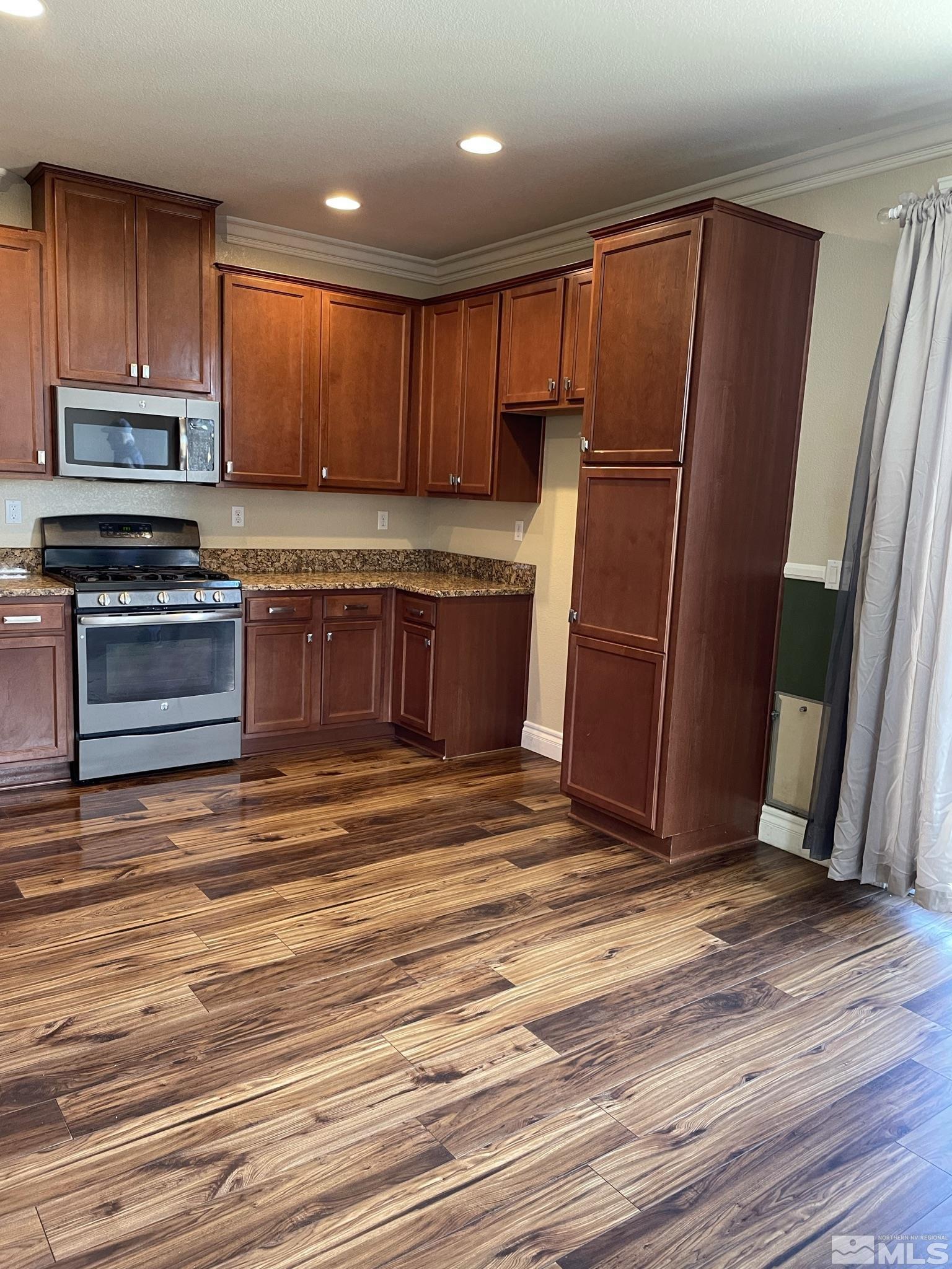 8945 Convair Way Reno, NV 89506 - Photo 10 of 26 a kitchen with stainless steel appliances granite countertop a refrigerator stove and cabinets