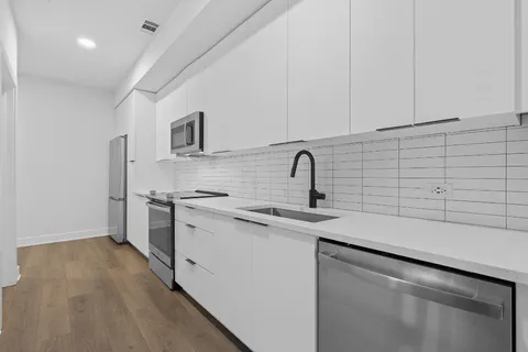 a kitchen with a sink a refrigerator and cabinets