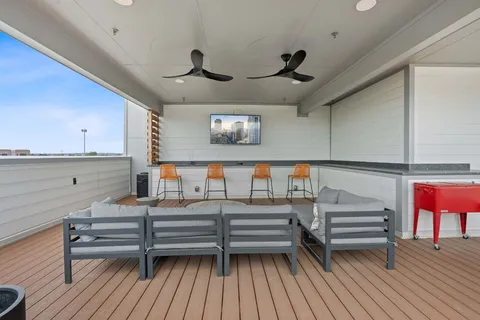 a patio with a table and chairs and potted plants