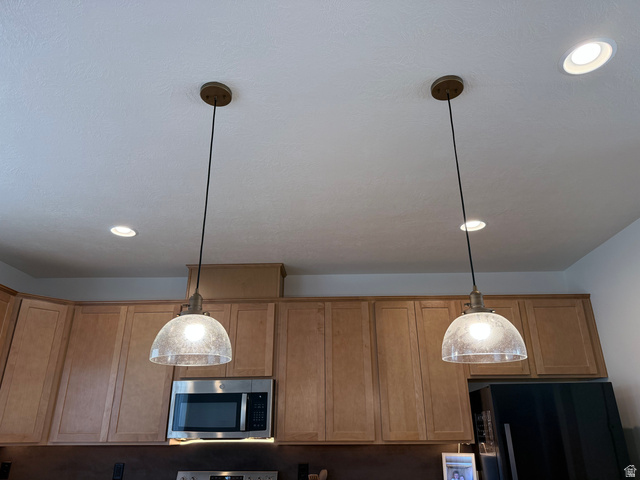 774 West 480 South American Fork, UT 84003 - Photo 23 of 76 Kitchen featuring two suspended pendant lights with seeded glass shades, recessed ceiling lighting, light wood-finish cabinetry, and stainless steel appliances including a microwave