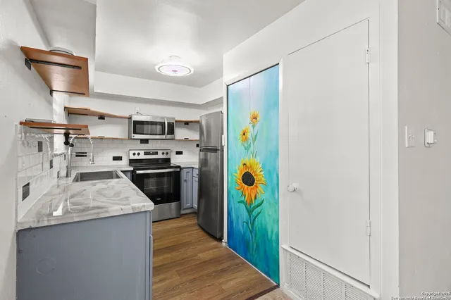 a kitchen with stainless steel appliances a stove a refrigerator and a sink