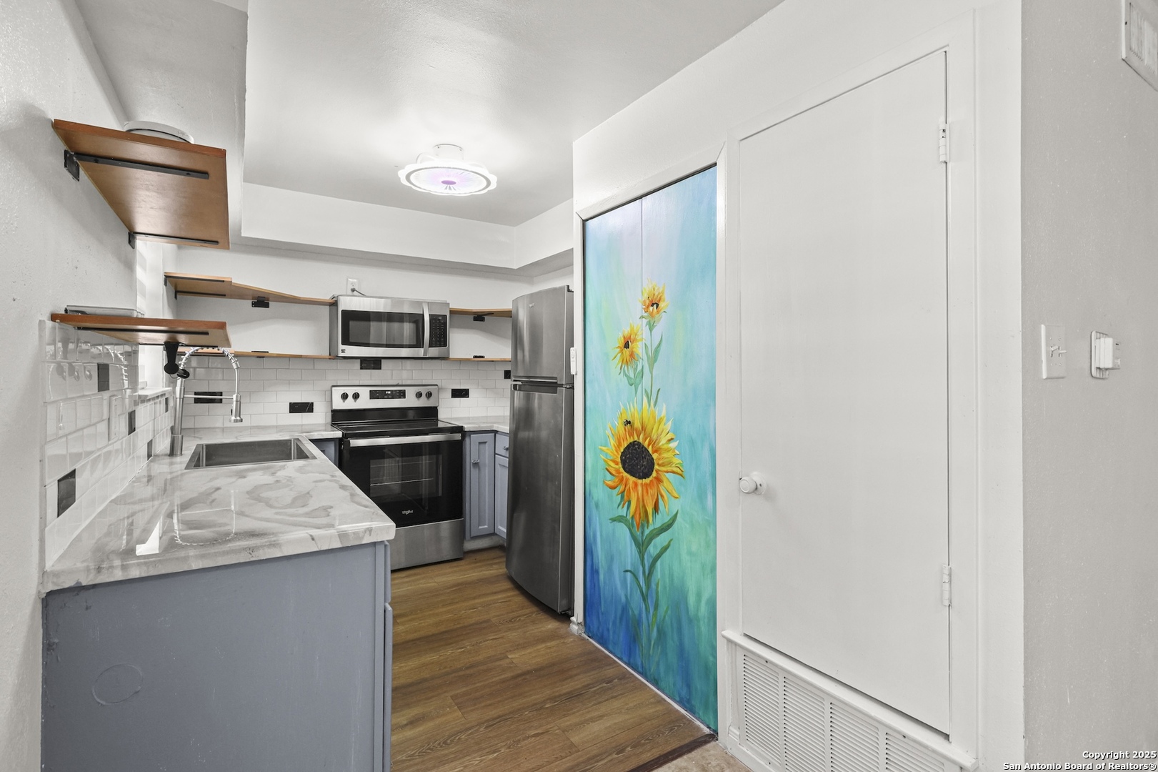 a kitchen with stainless steel appliances a stove a refrigerator and a sink