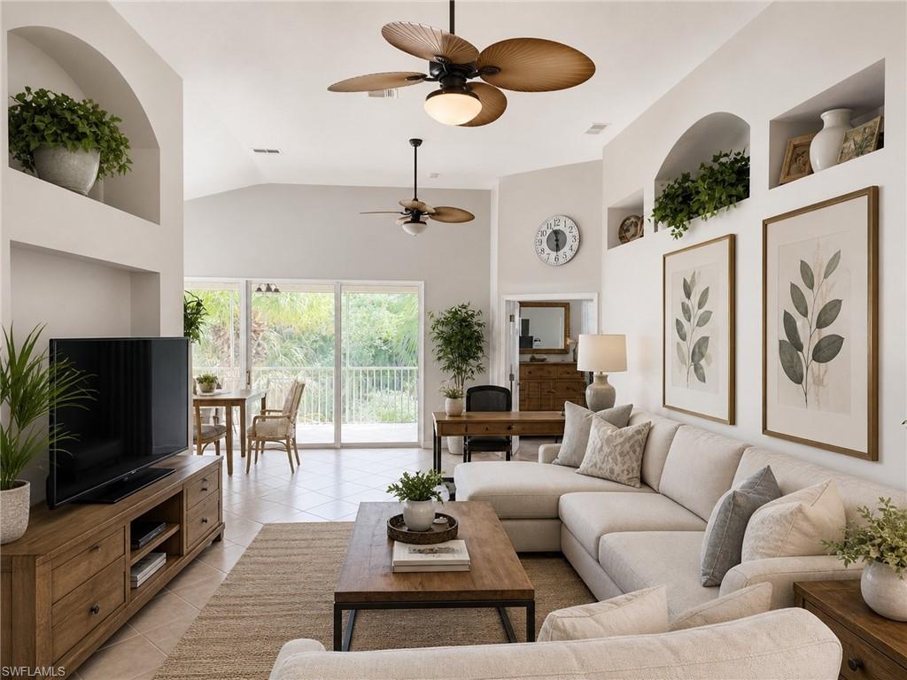 19081 Ridgepoint Drive, Unit 201 Estero, FL 33928 - Photo 6 of 42 a living room with furniture a flat screen tv and a floor to ceiling window