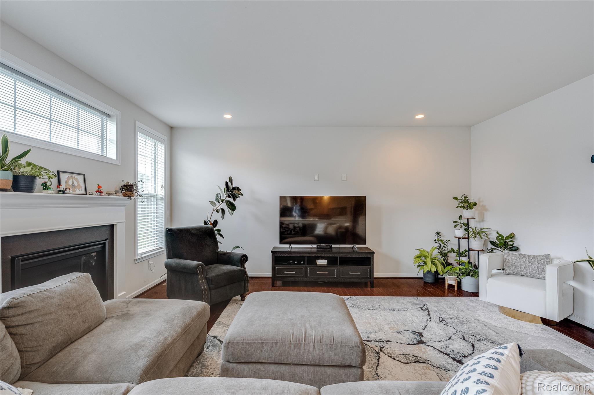 51011 Rockingham Drive Canton, MI 48188 - Photo 26 of 74 Living room featuring a glass covered fireplace, wood finished floors, and recessed lighting