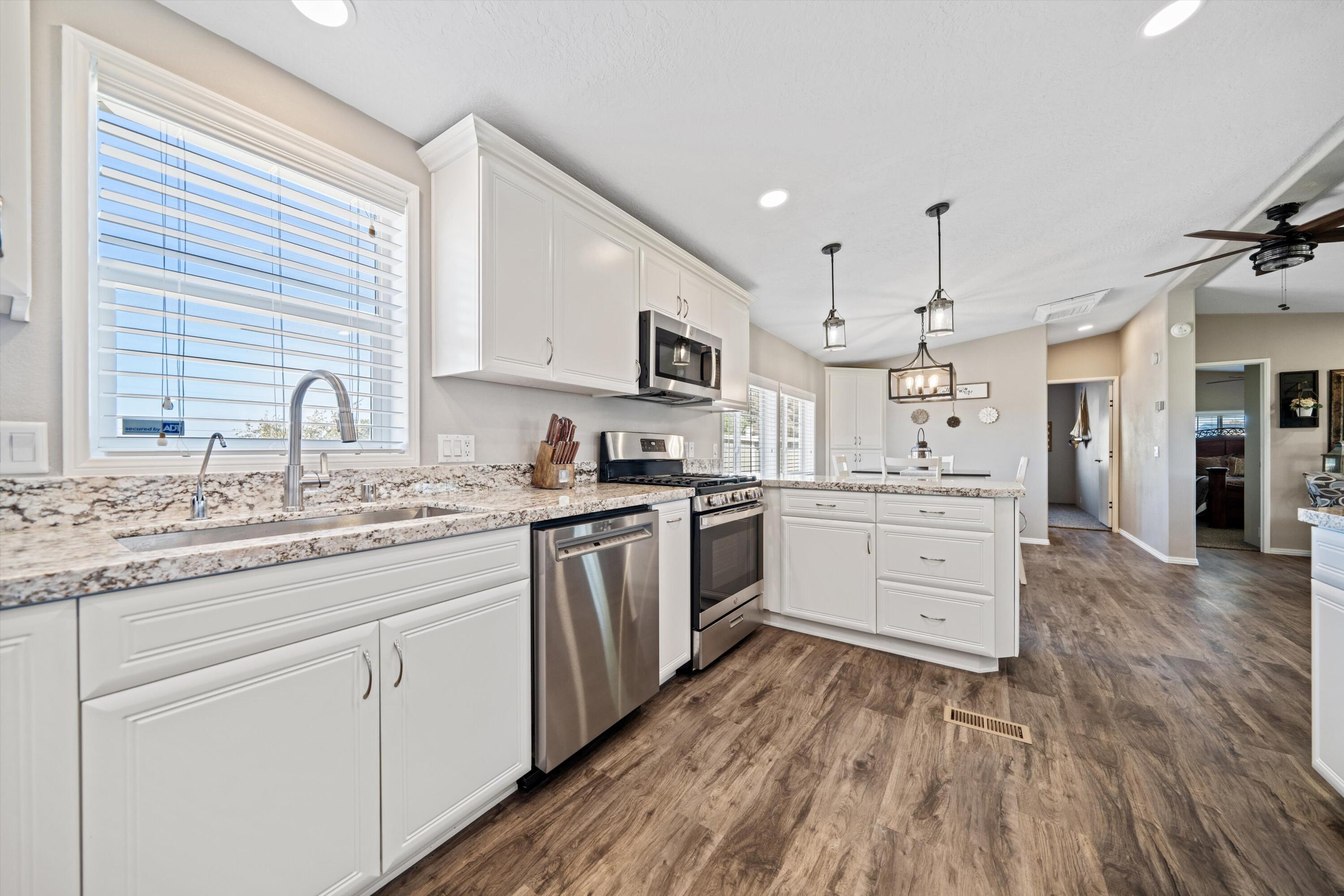 48197 Valley Center Road Newberry Springs, CA 92365 - Photo 12 of 32 a kitchen with granite countertop a sink cabinets stainless steel appliances and a window
