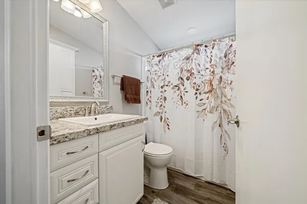 a bathroom with a granite countertop sink toilet and shower
