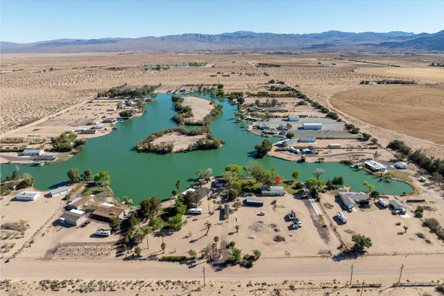an aerial view of ocean and residential houses with outdoor space