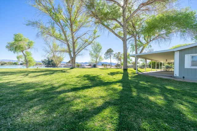 a view of a house with a big yard and palm trees
