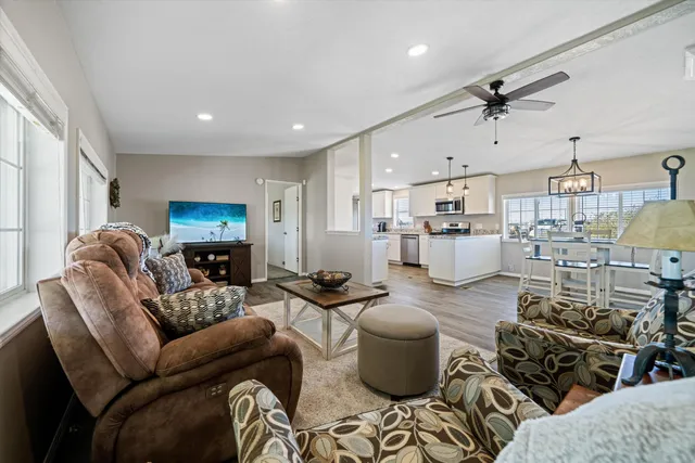 a living room with furniture a kitchen view and a chandelier