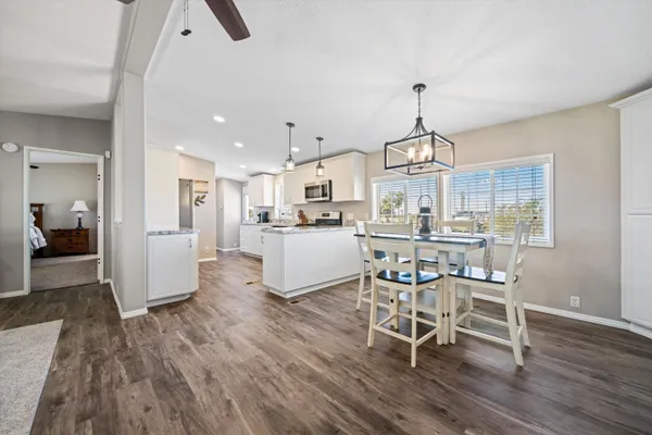 a view of a dining room and livingroom with furniture wooden floor a chandelier