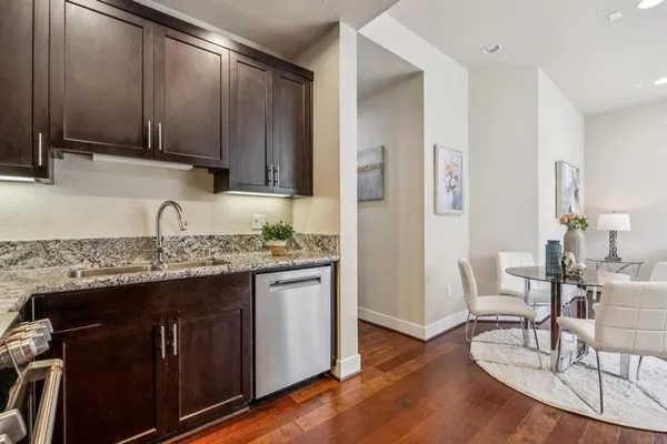 a kitchen with granite countertop a stove a microwave a sink and cabinets