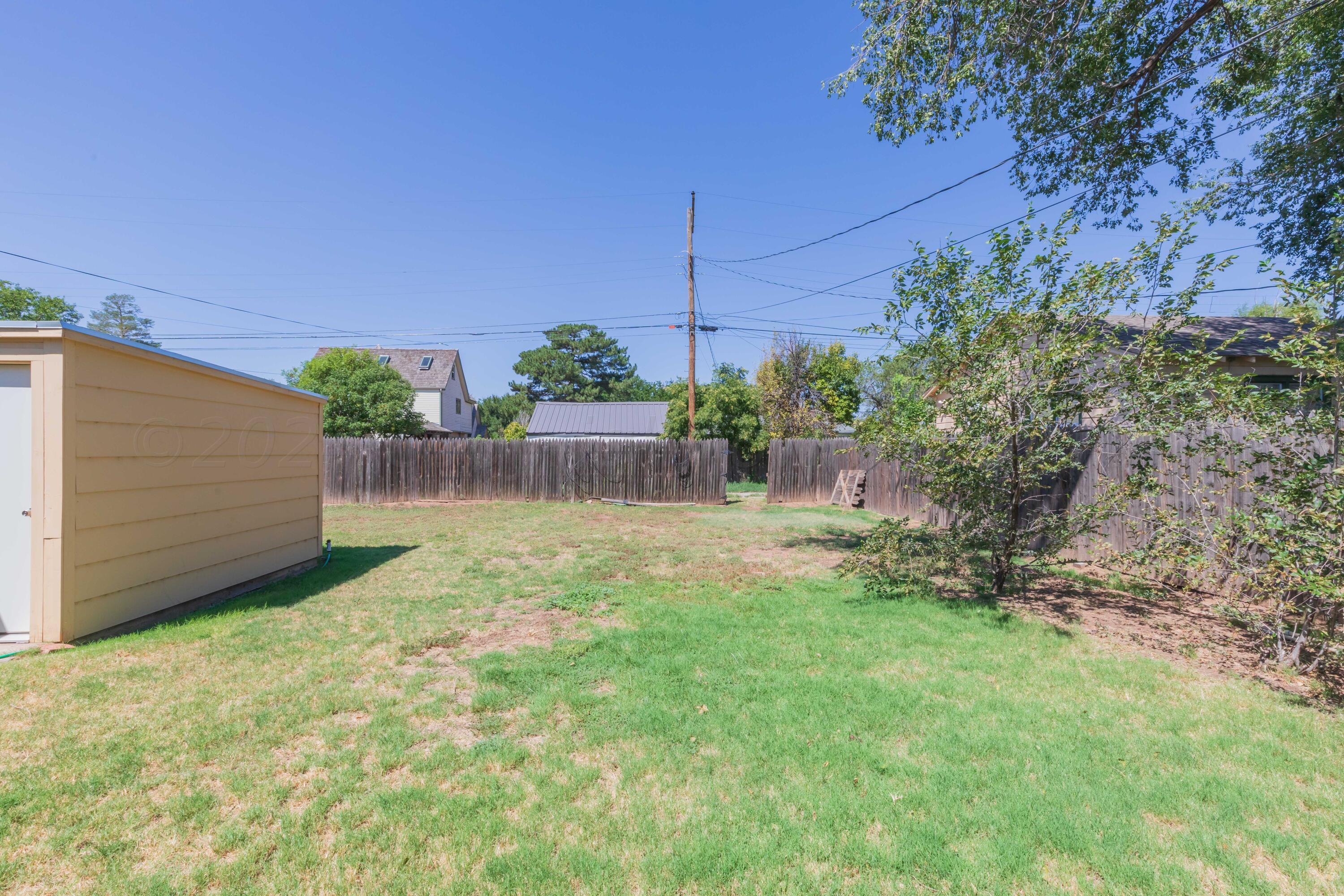 3002 South Polk Street Amarillo, TX 79109 - Photo 36 of 36 a view of a backyard with plants and a large tree