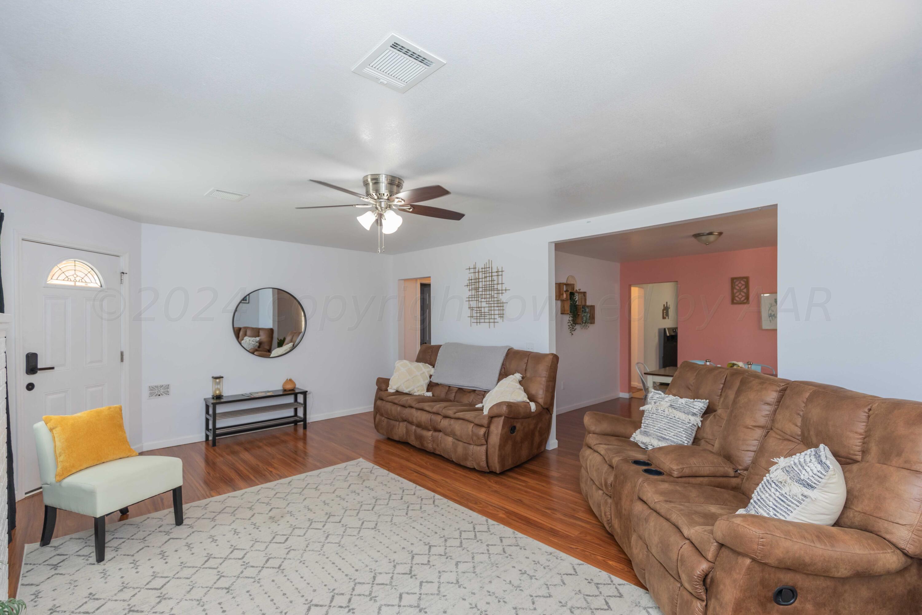 3002 South Polk Street Amarillo, TX 79109 - Photo 6 of 36 a living room with furniture a clock on wall and a large window