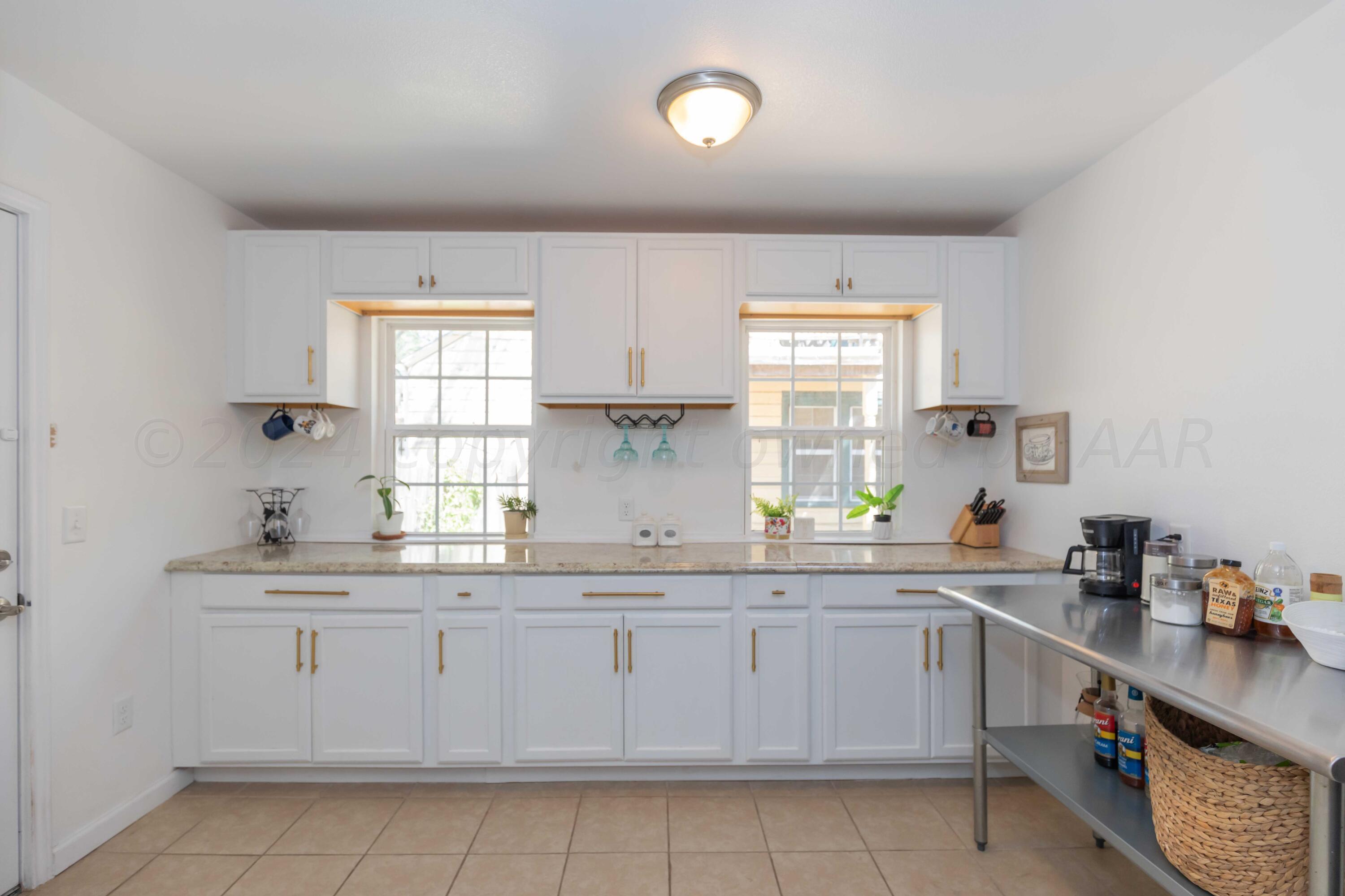 3002 South Polk Street Amarillo, TX 79109 - Photo 8 of 36 a kitchen with a sink window and cabinets