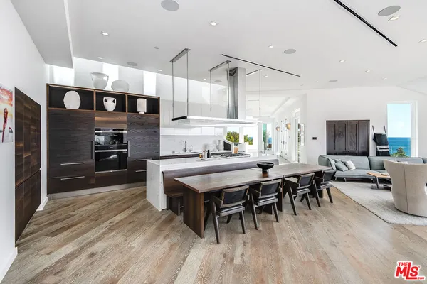 a kitchen with a table chairs and white cabinets