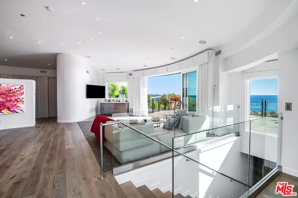 a spacious bedroom with a bed and large windows
