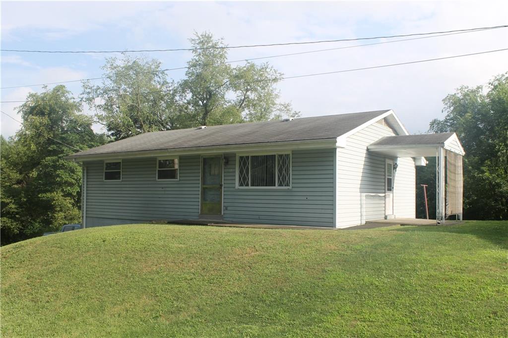 a front view of a house with yard and trees